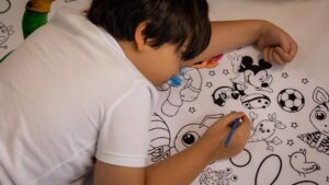 Boy coloring drawings during Dana Energy Children’s Day celebration